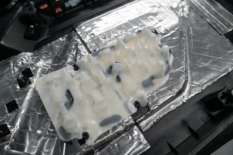 Back of Ford Bronco door panel with ResoNix CLD Squares applied and close up of insert